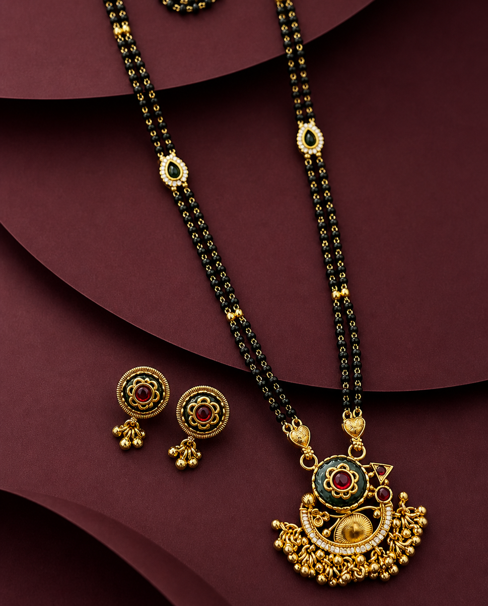 Gold necklace with black beads and matching earrings on a maroon background