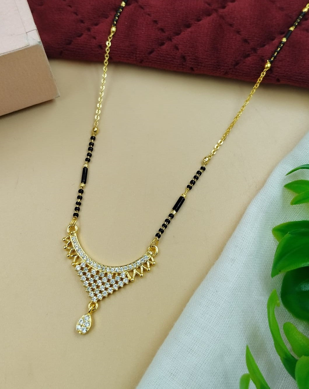 Elegant women’s mangalsutra designed with a smooth curved stone-inspired accent