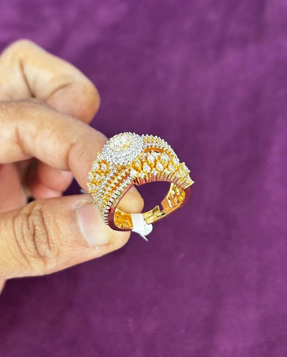 Gold ring with diamonds held by a hand against a purple background