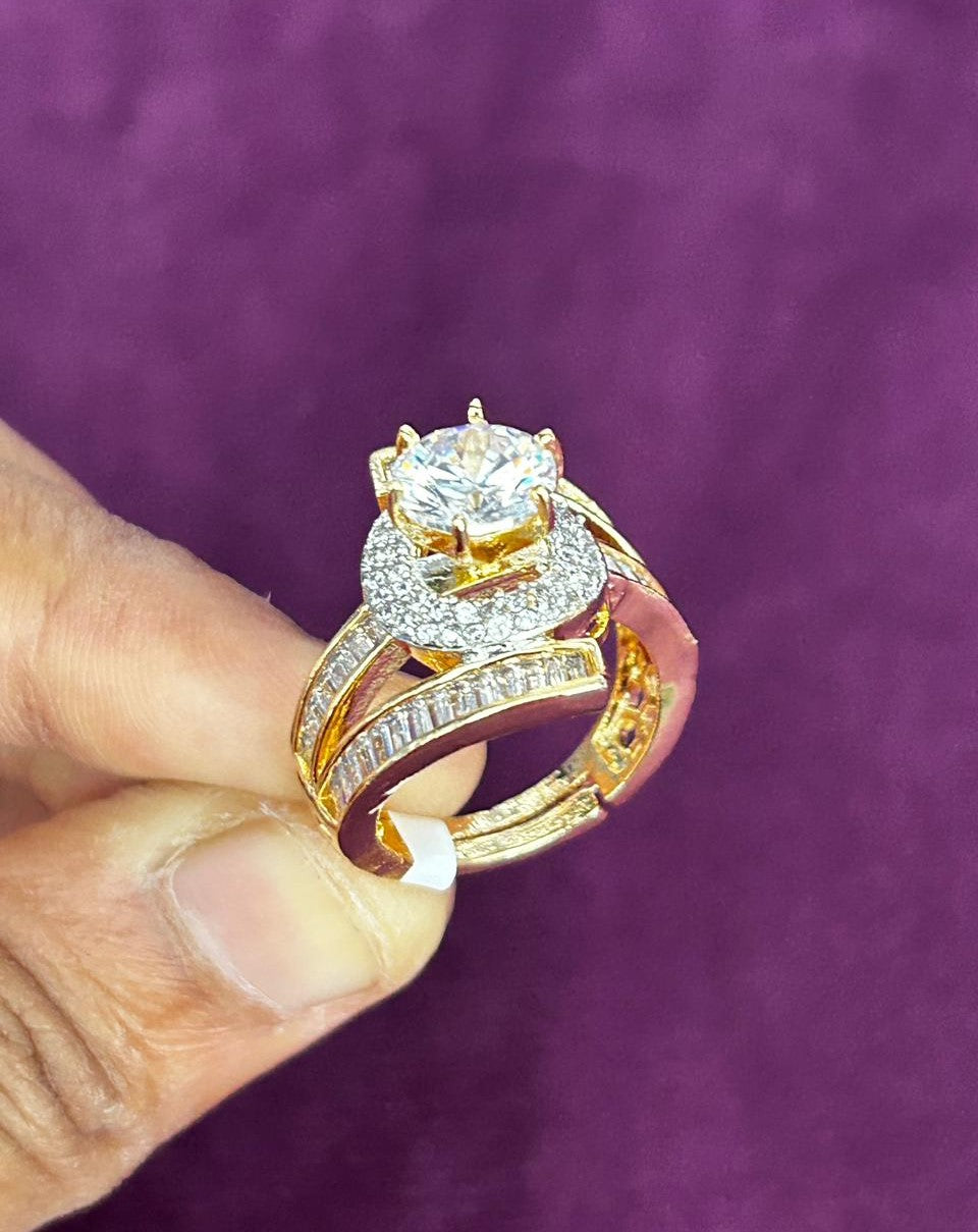Gold ring with a large diamond held by a hand against a purple background
