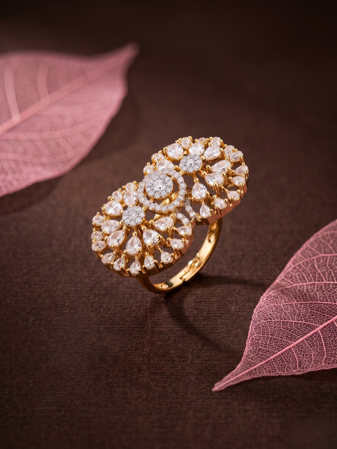 Gold ring with diamonds on a brown background with pink leaves