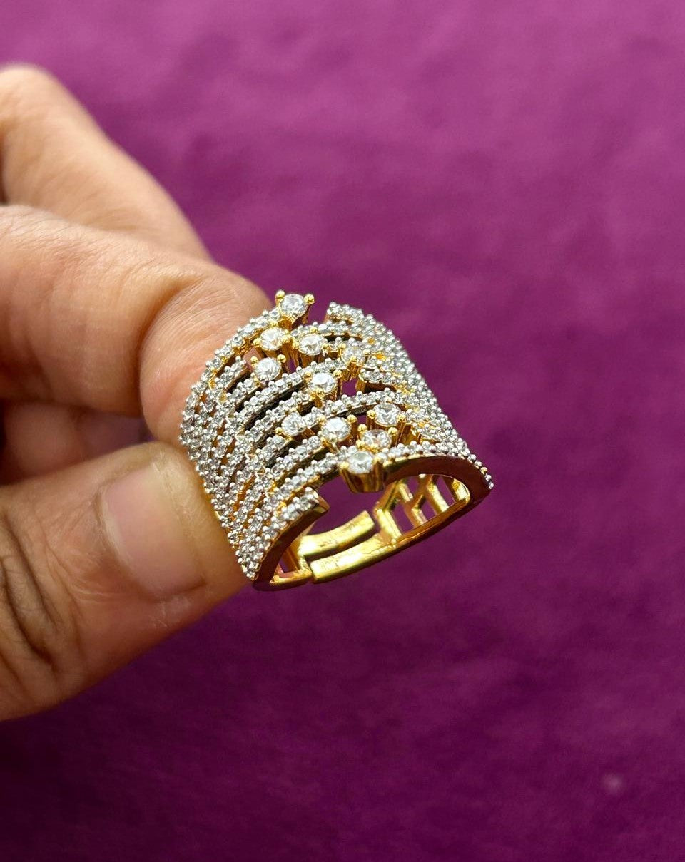 Gold ring with diamonds held by a hand against a purple background