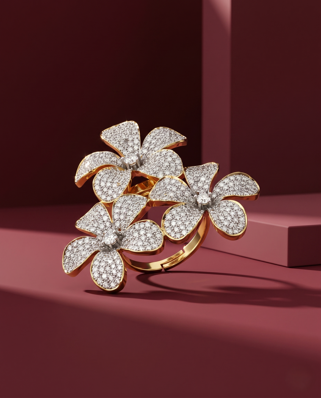 Gold ring with floral design and diamonds on a red background