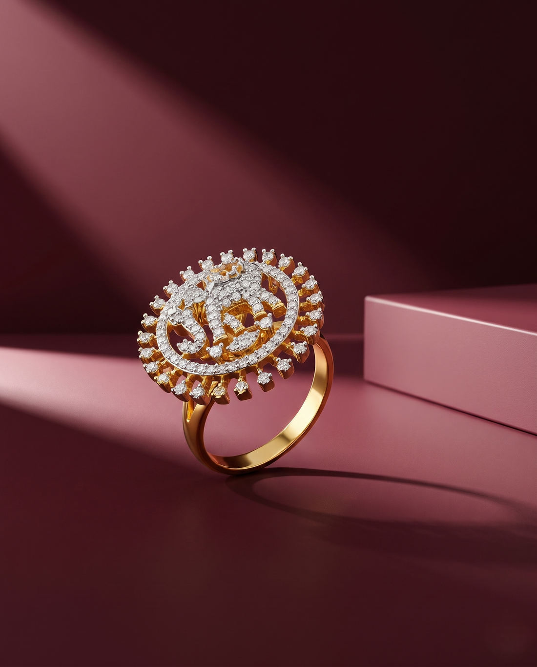 Gold ring with intricate design on a pink surface