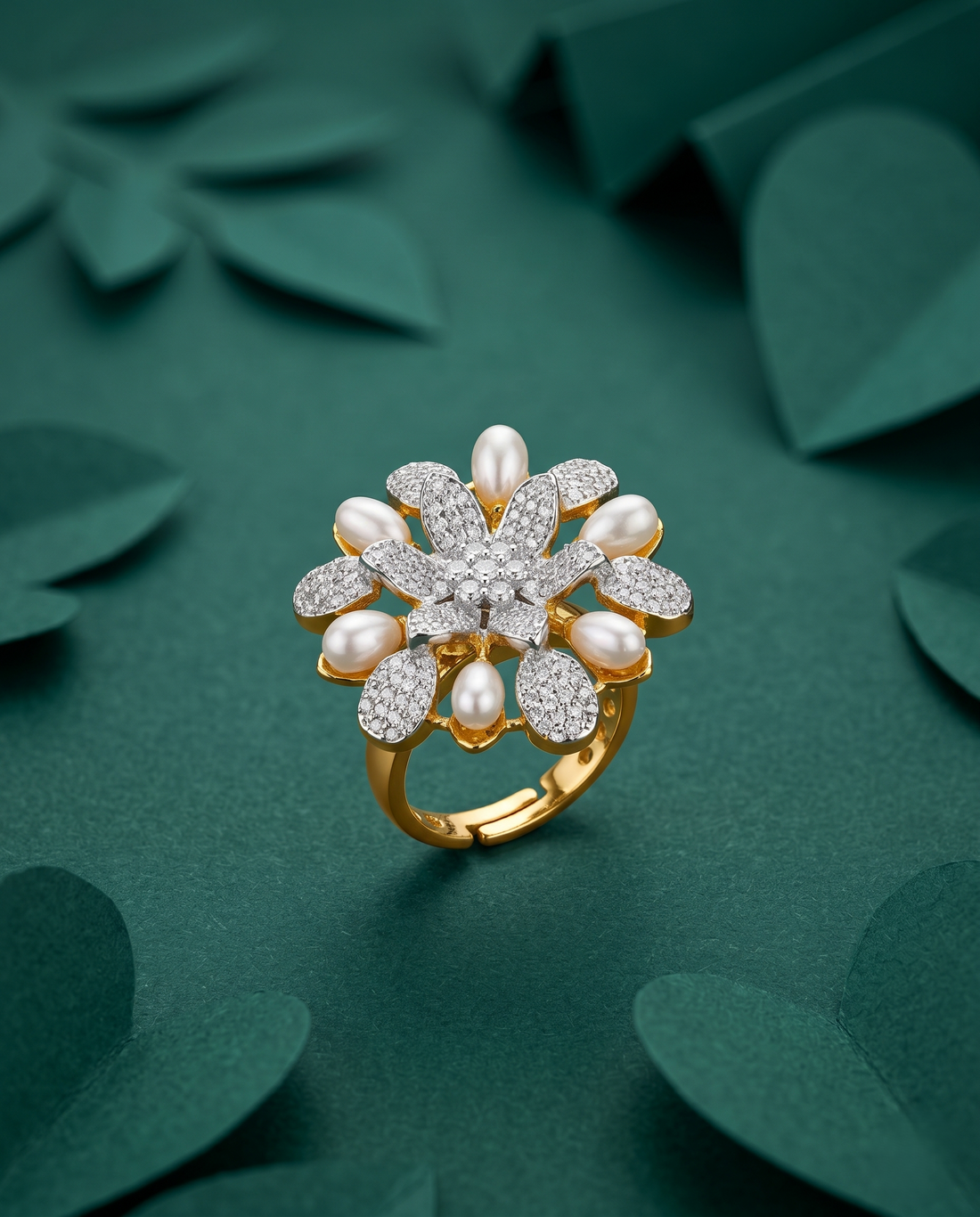 Gold ring with pearls and diamonds on a green leafy background
