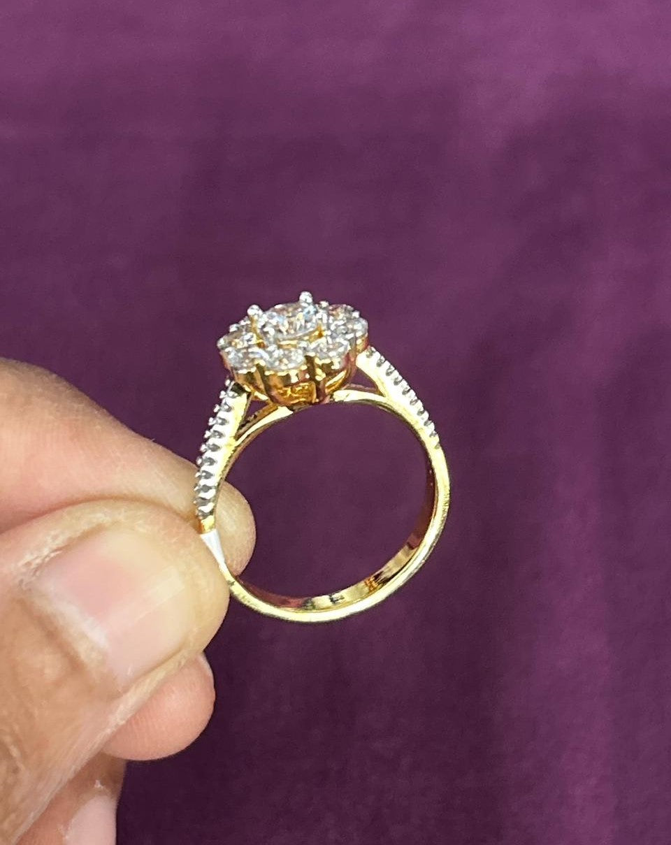 Gold ring with diamonds held by a hand against a purple background