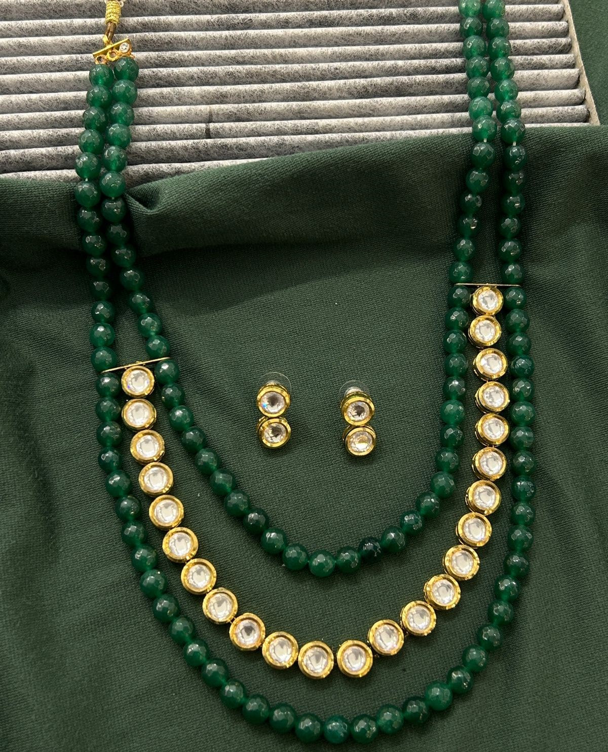 Elegant gold-finish necklace and stud earring set accented with green detailing