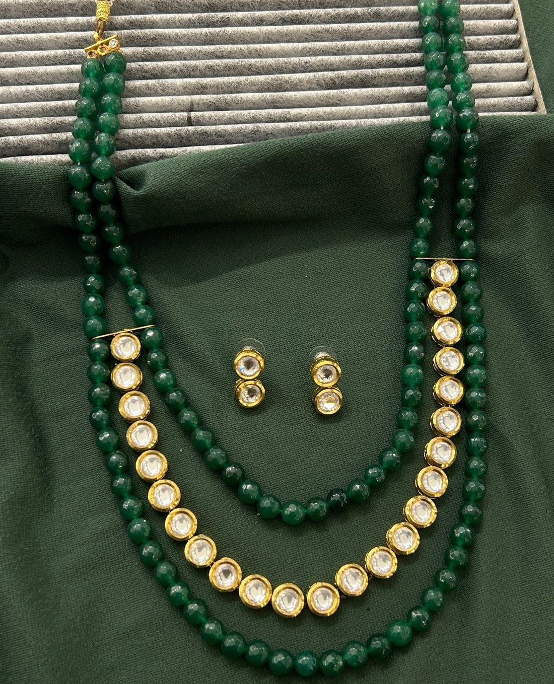 Elegant gold-finish necklace and stud earring set accented with green detailing