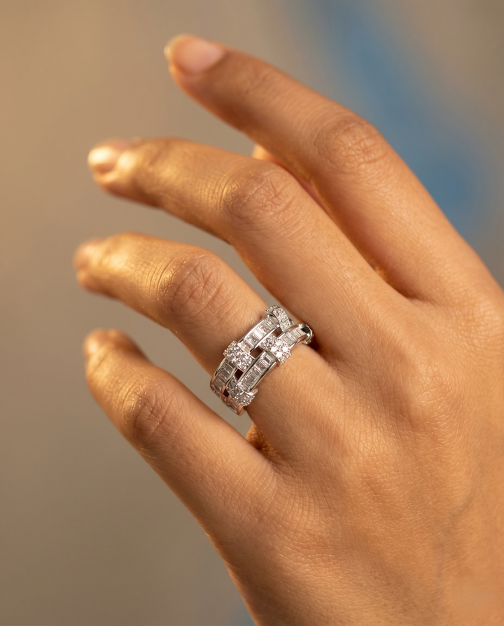 Hand wearing a diamond ring with a blurred background