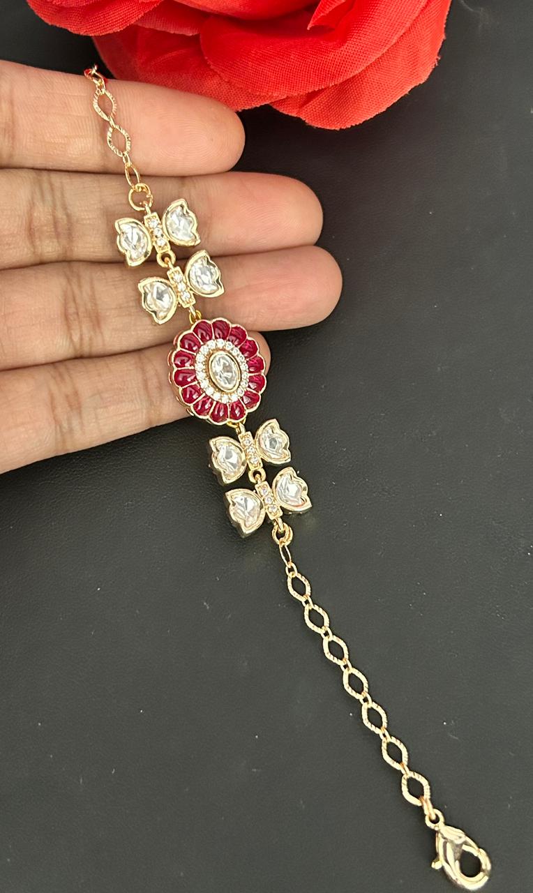Jewelry piece with floral design held by a hand against a dark background