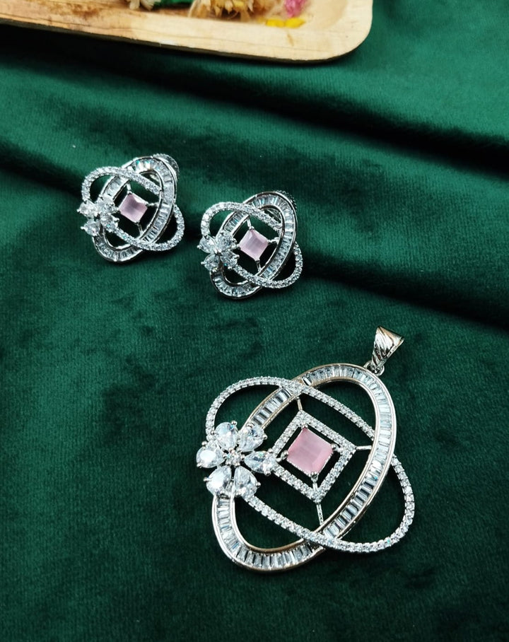 Jewelry set with a pendant and earrings on a green fabric background