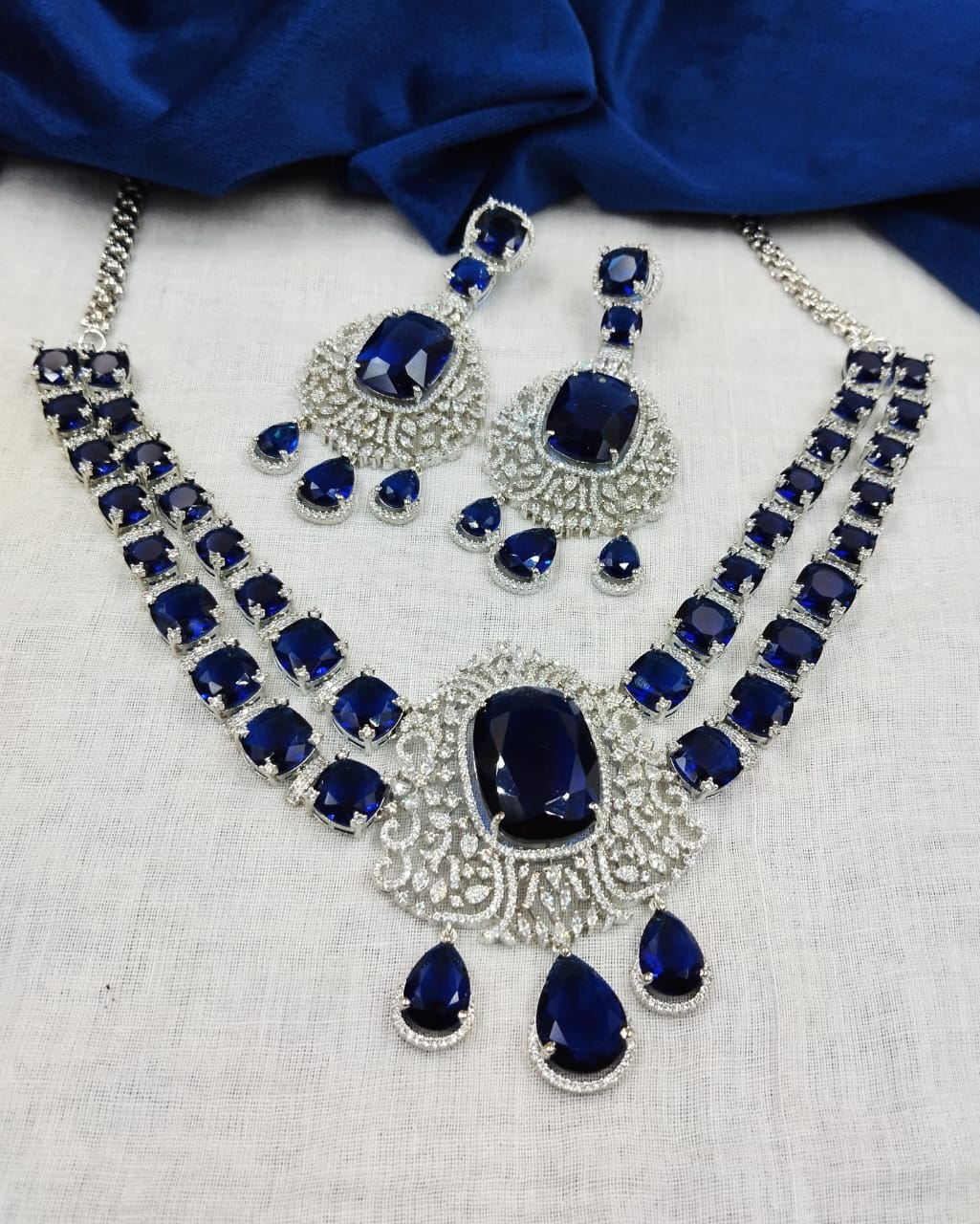 Silver finish diamond style necklace set featuring royal blue stone detailing with earrings