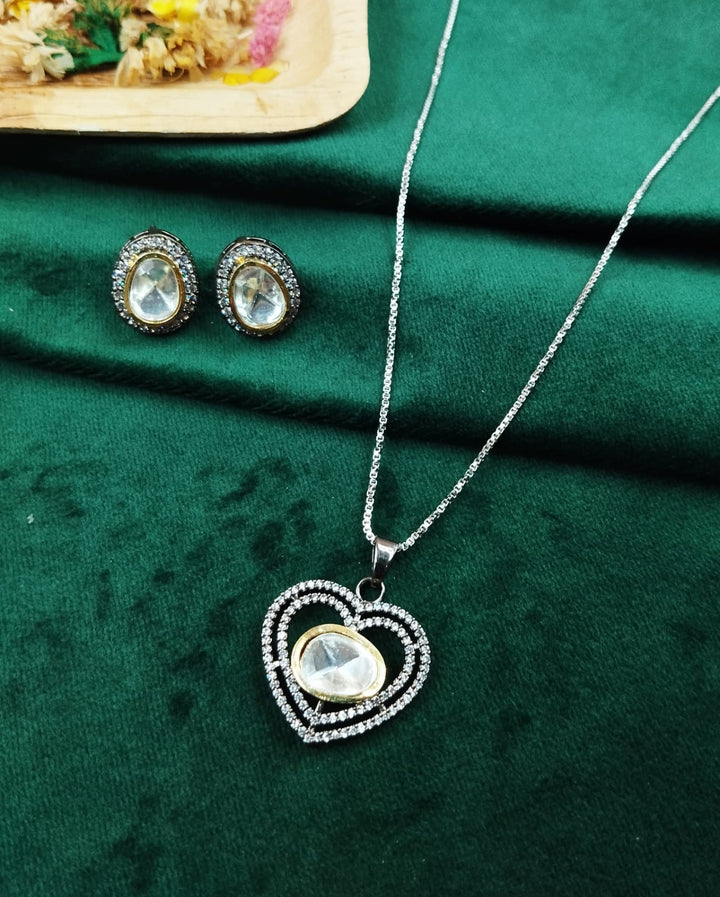 Jewelry set with heart-shaped pendant and earrings on a green fabric background