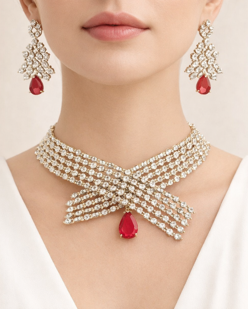 Jewelry set with necklace and earrings featuring red gemstones on a neutral background