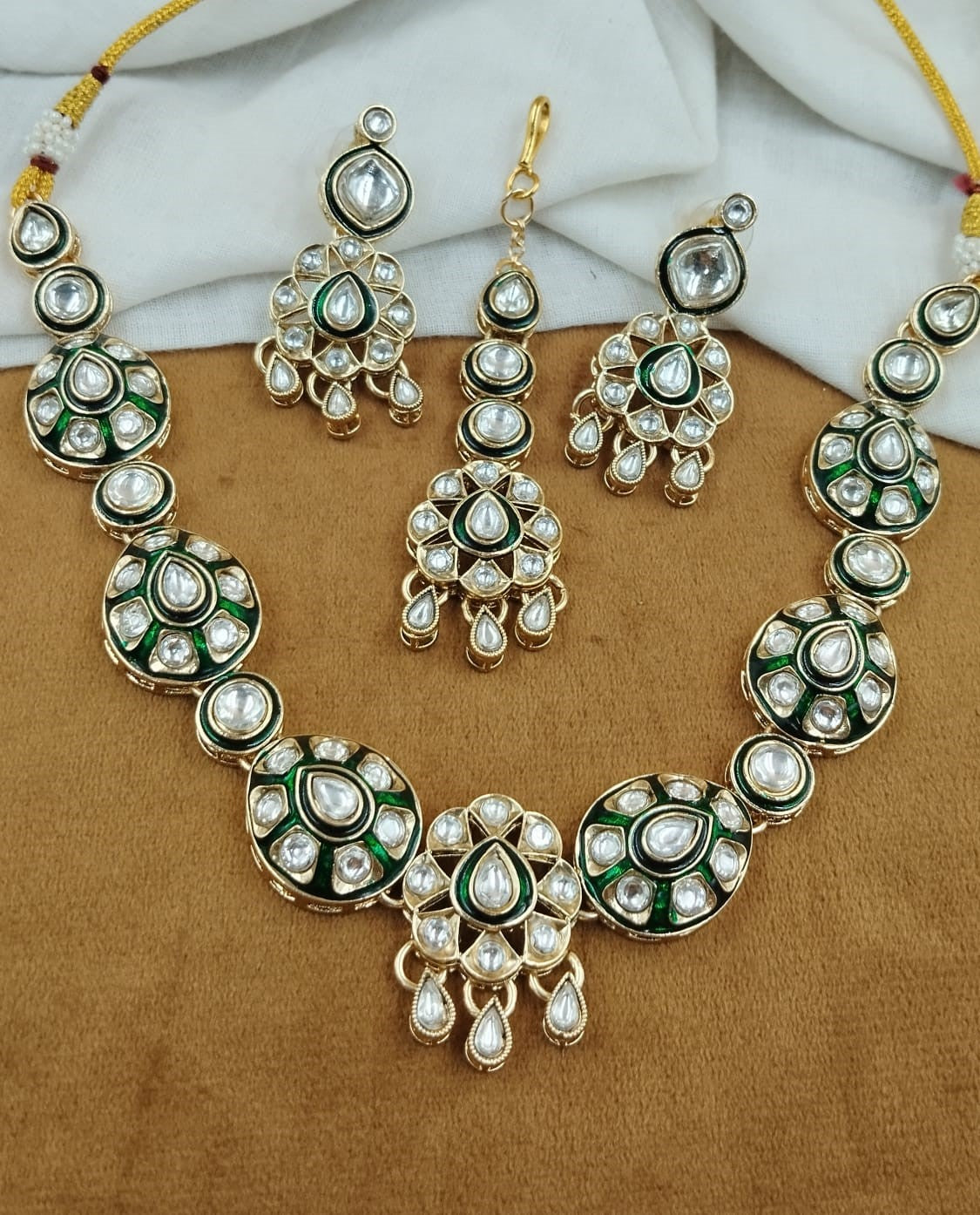 Heritage-inspired adornment showcasing refined kundan work with coordinated headpiece