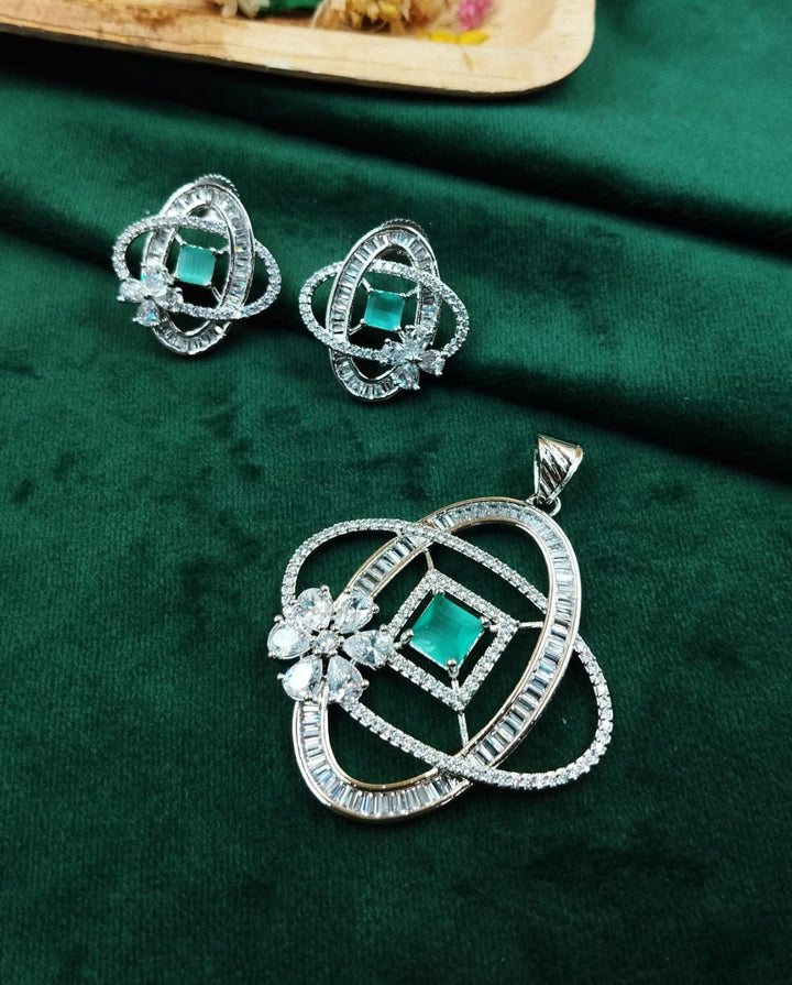 Jewelry set with pendant and earrings on a green fabric background