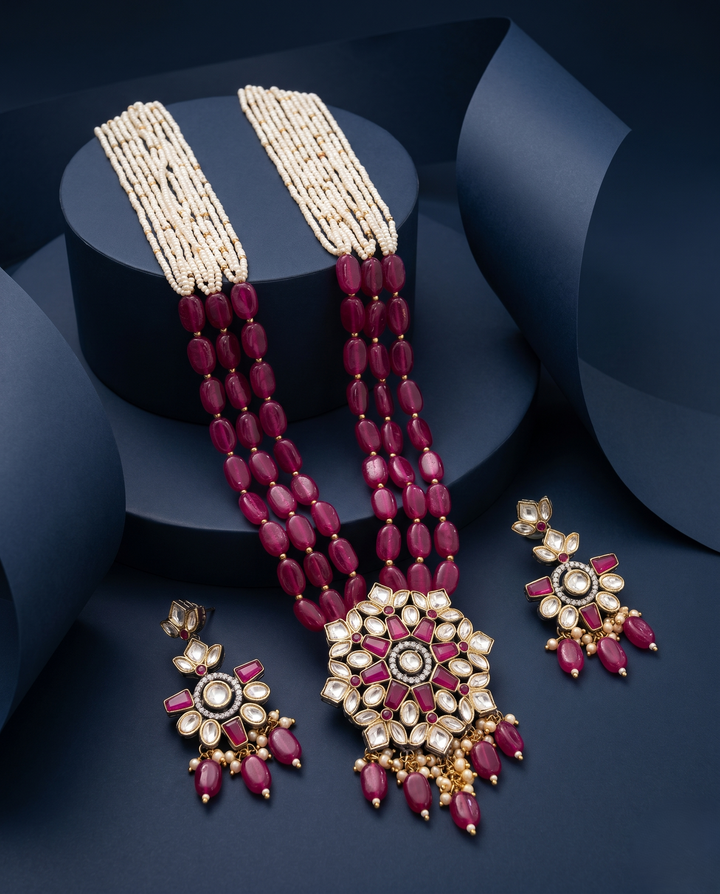 Jewelry set with red beads and gold accents on a dark background