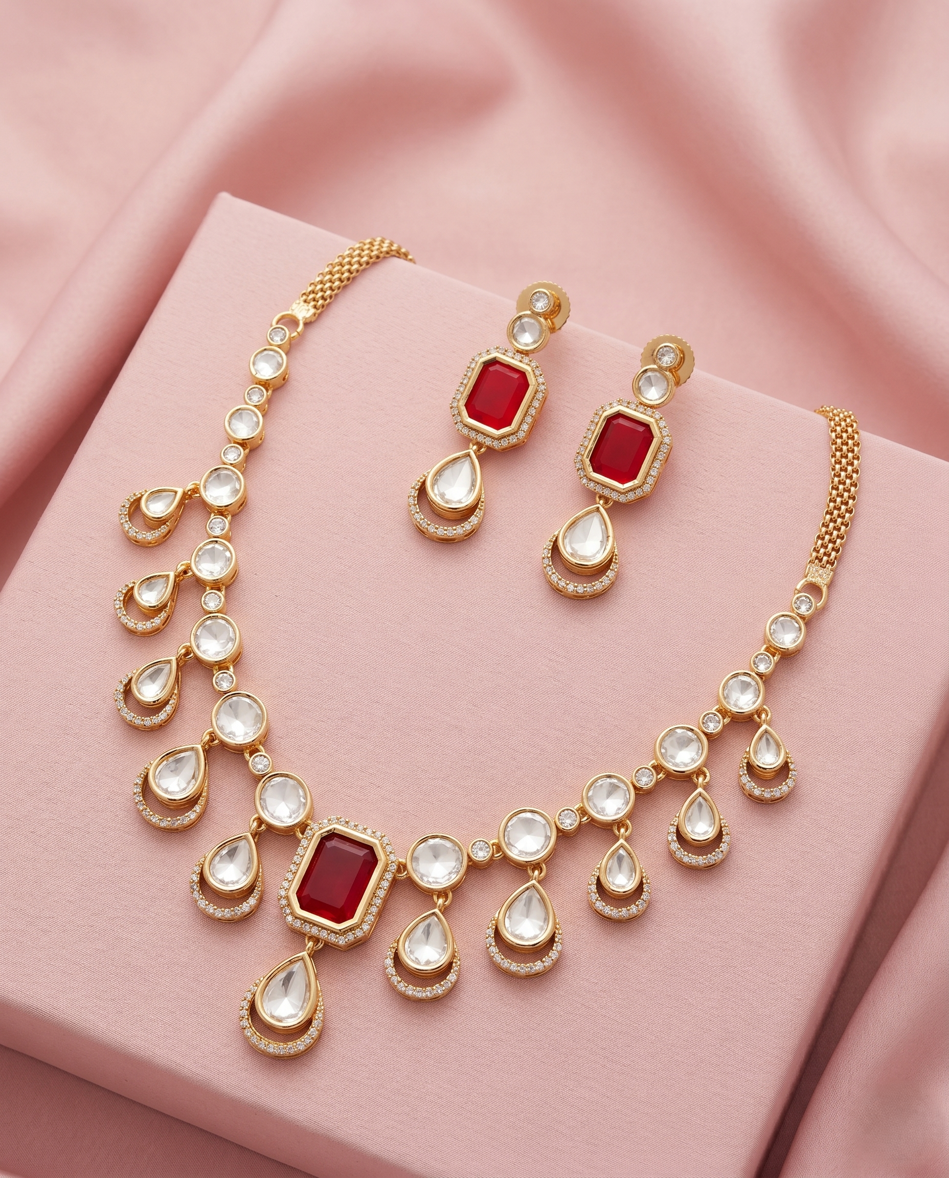 Jewelry set with necklace and earrings on a pink fabric background