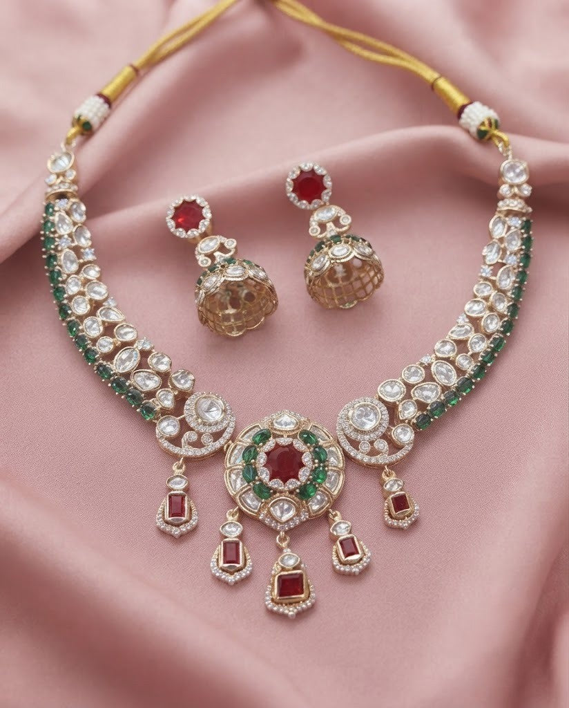Kundan  necklace set with matching jhumka earrings in premium gold finish displayed on a soft pink fabric background.