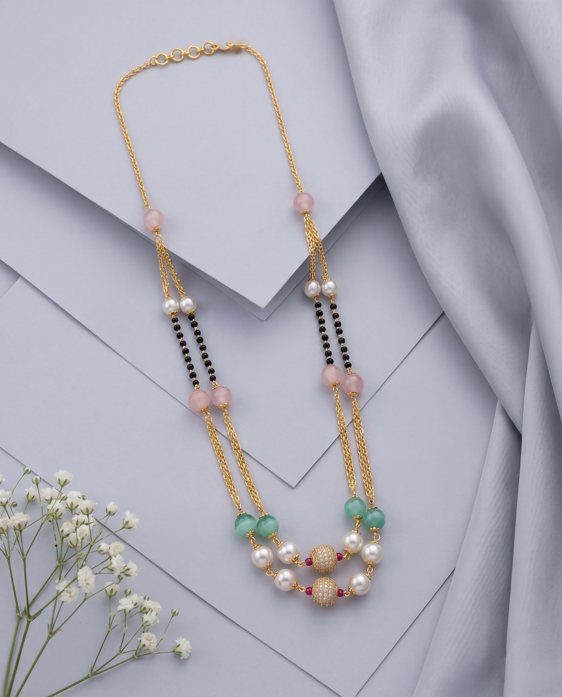 Necklace with pearls and gemstones on a light grey background