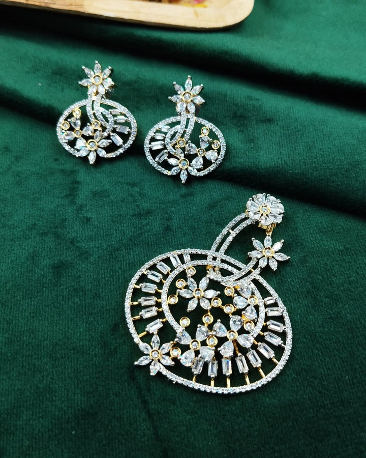 Ornate earrings on a green fabric background