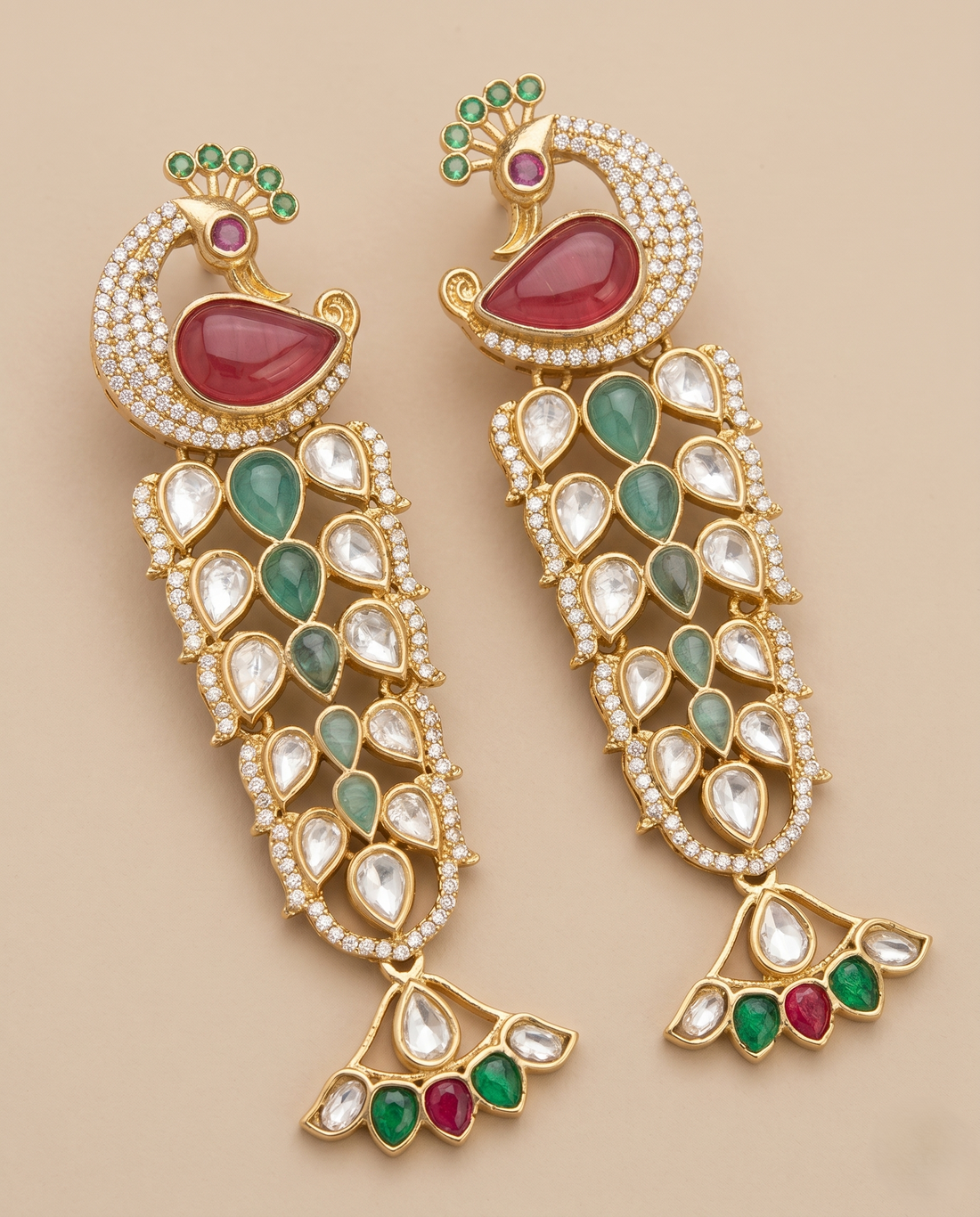 Ornate earrings with gemstones on a beige background