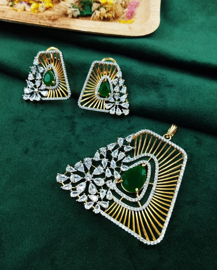 Ornate earrings with green gemstones on a green fabric background