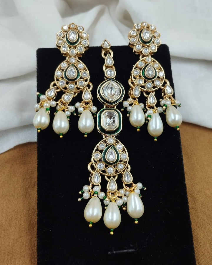 Close up view of polki kundan necklace with pearl drops paired with matching earrings in gold finish