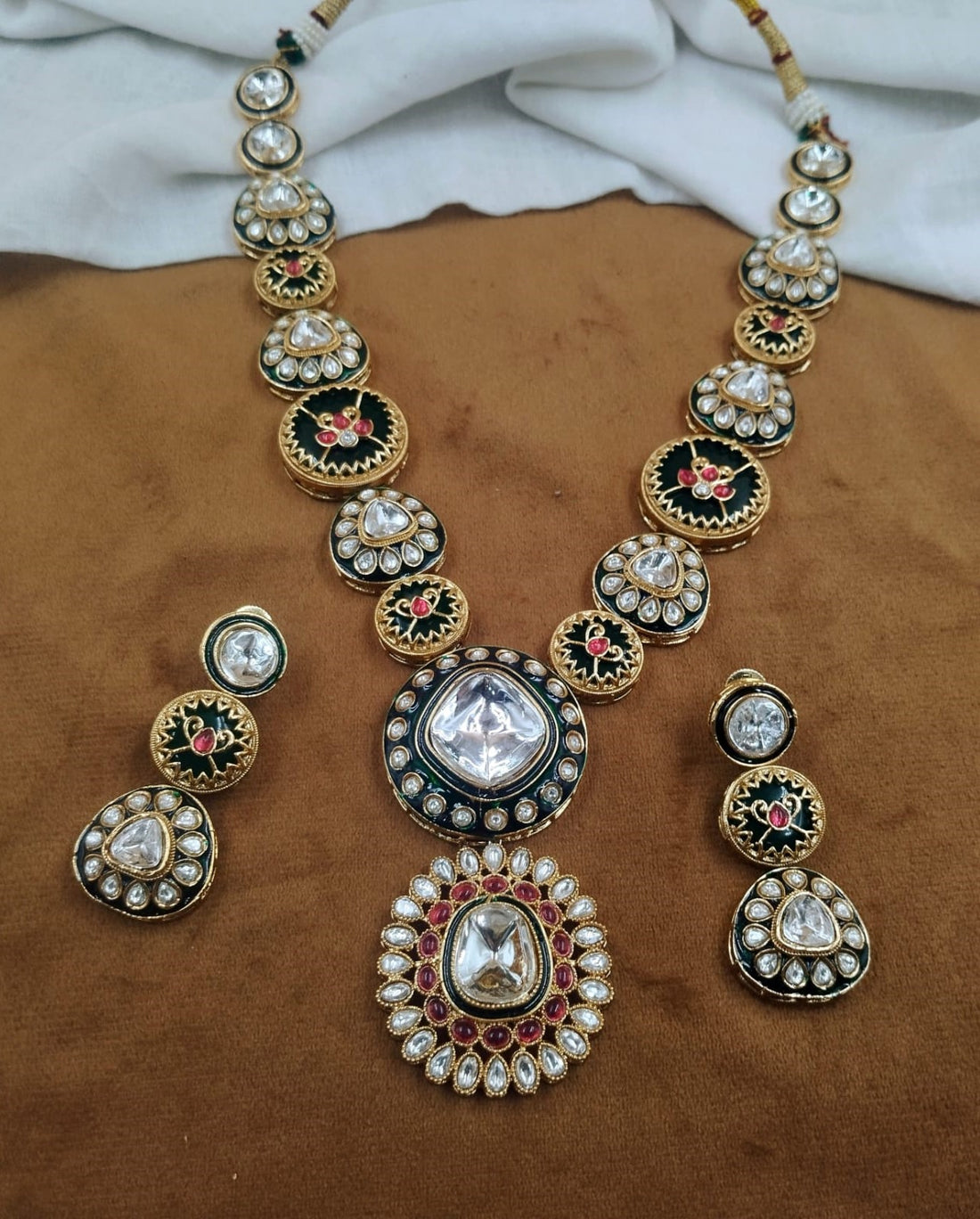 Polki kundan necklace set featuring green and red enamel work with matching earrings, traditional design