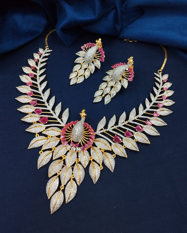Ornate necklace and earrings set on a dark blue fabric background