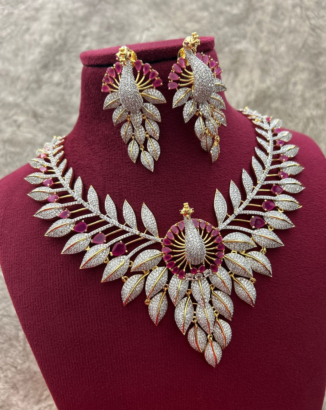 Ornate necklace and earrings set on a mannequin bust with a neutral background