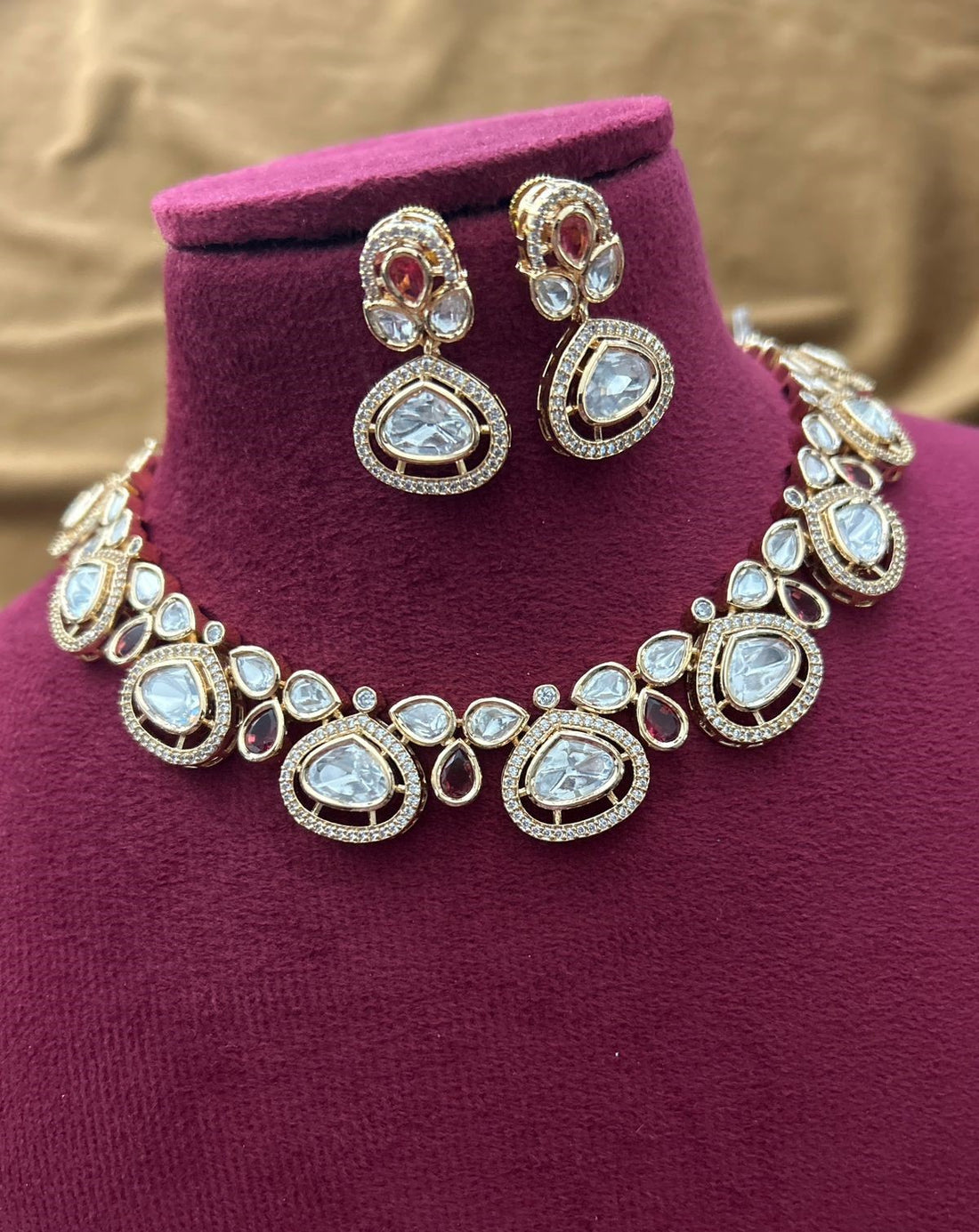 Bridal jewellery ensemble featuring classic white kundan craftsmanship and crimson details