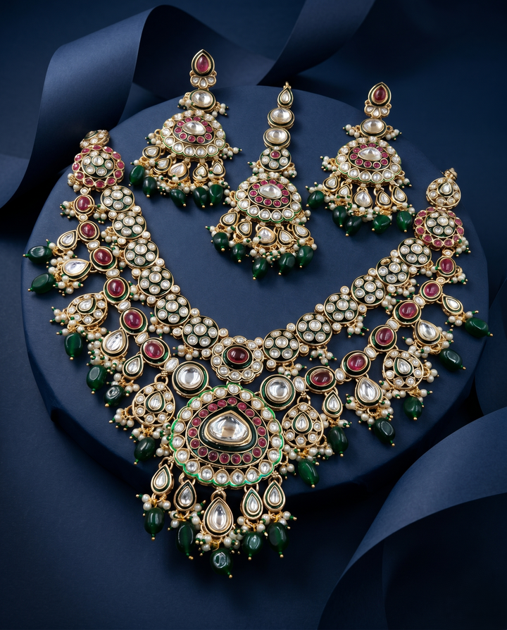 Ornate necklace and earrings set with gemstones on a dark blue background