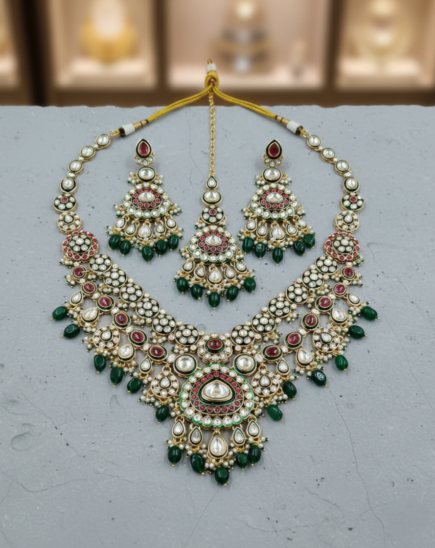 Green and red kundan bridal necklace set paired with matching earrings and maang tikka