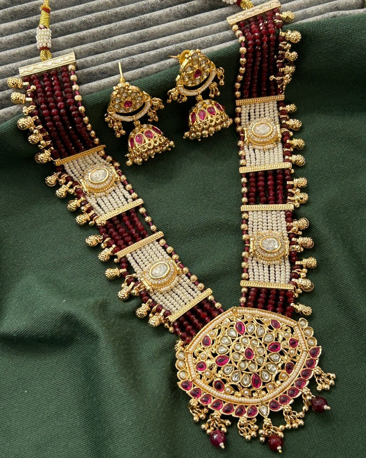 Elegant bridal necklace and earring set highlighted by pearl detailing and rich bead