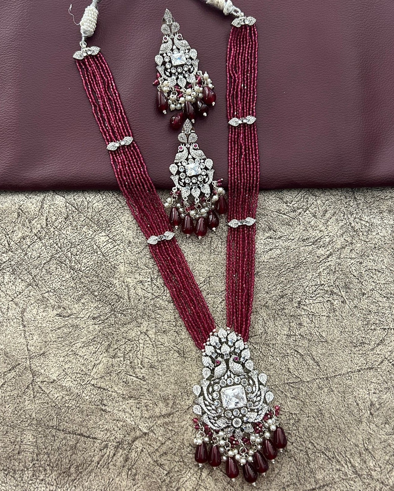 Ornate necklace with maroon beads and silver accents daimond used for making but imitation 