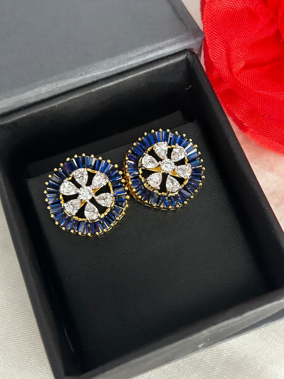 Pair of decorative earrings in a black box with a red fabric background