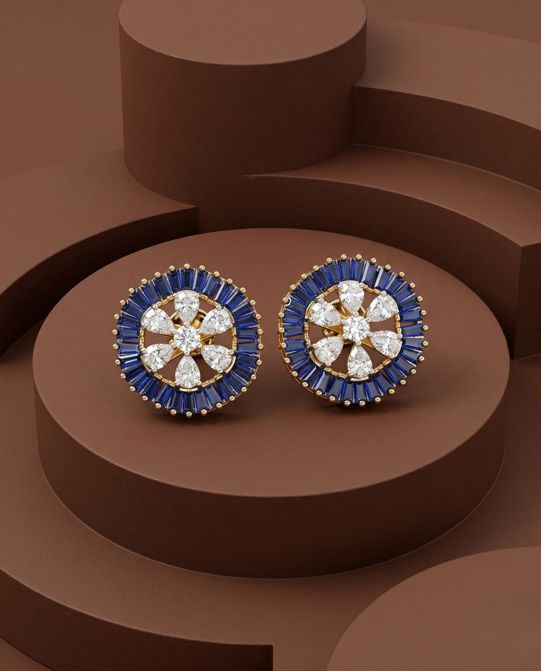 Pair of earrings with blue and gold design on a brown geometric background