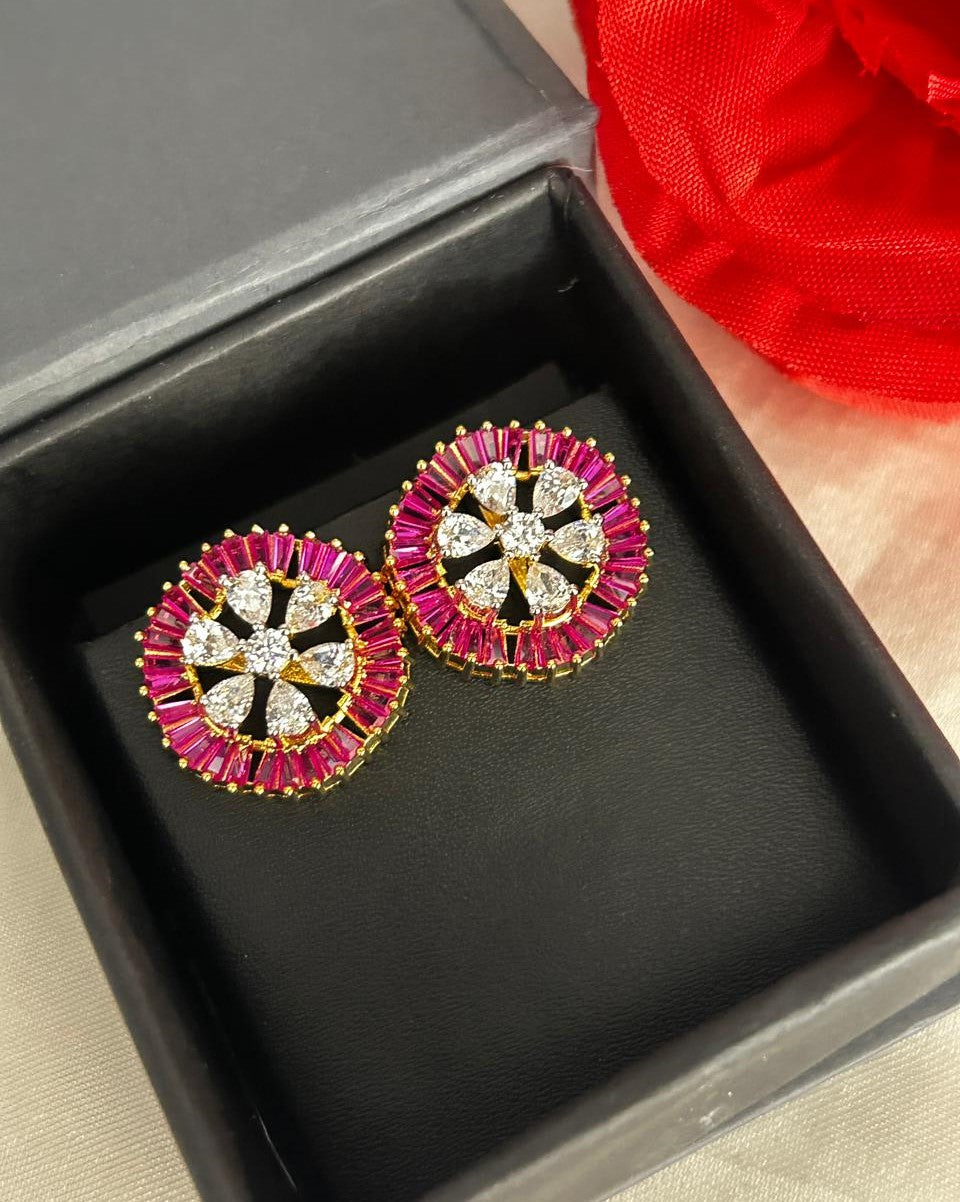 Pair of earrings with pink and gold accents in a black box.