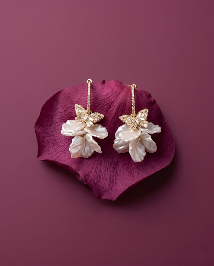 Pair of floral earrings on a purple petal against a matching background