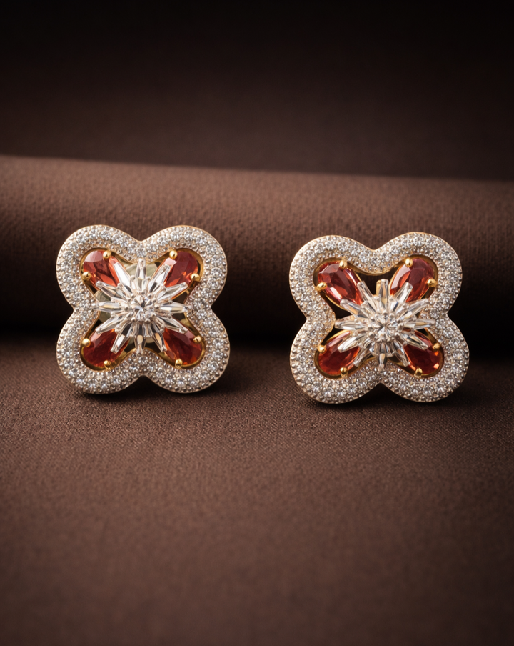 Pair of floral earrings with gemstones on a brown background