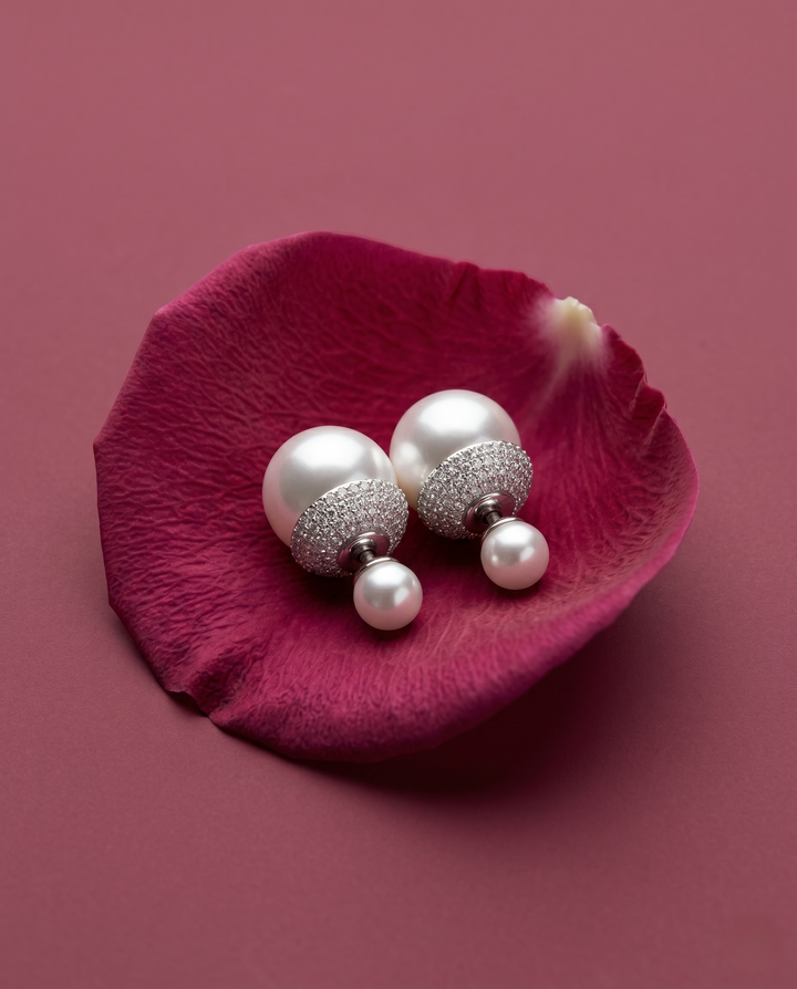 Pearl earrings on a pink petal with a pink background