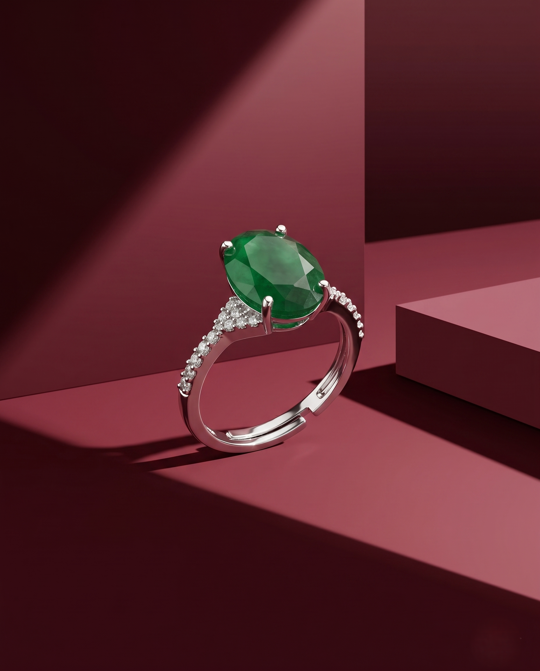 Ring with a green gemstone on a red geometric background