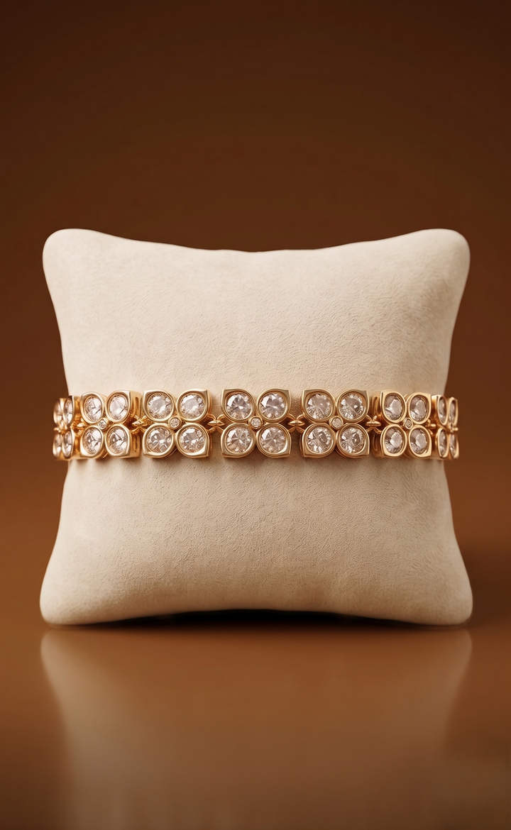 Rose gold bracelet with clear stones on a beige pillow against a brown background
