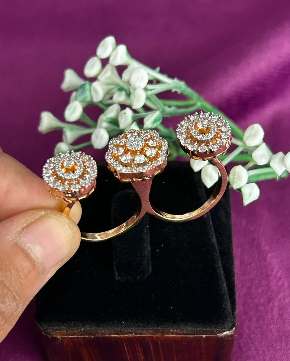 Rose gold earrings with diamond accents held over a black box against a purple background.