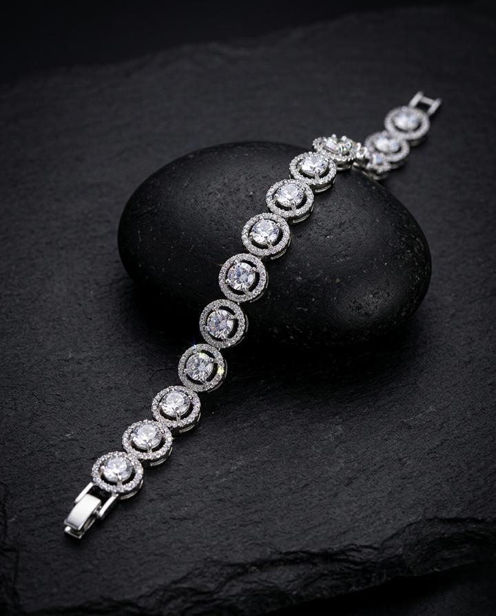 Silver bracelet with clear stones on a dark stone surface