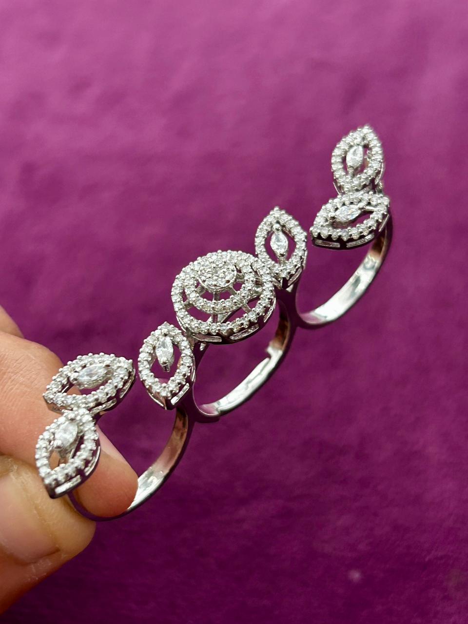 Silver bracelet with diamond accents held against a purple background