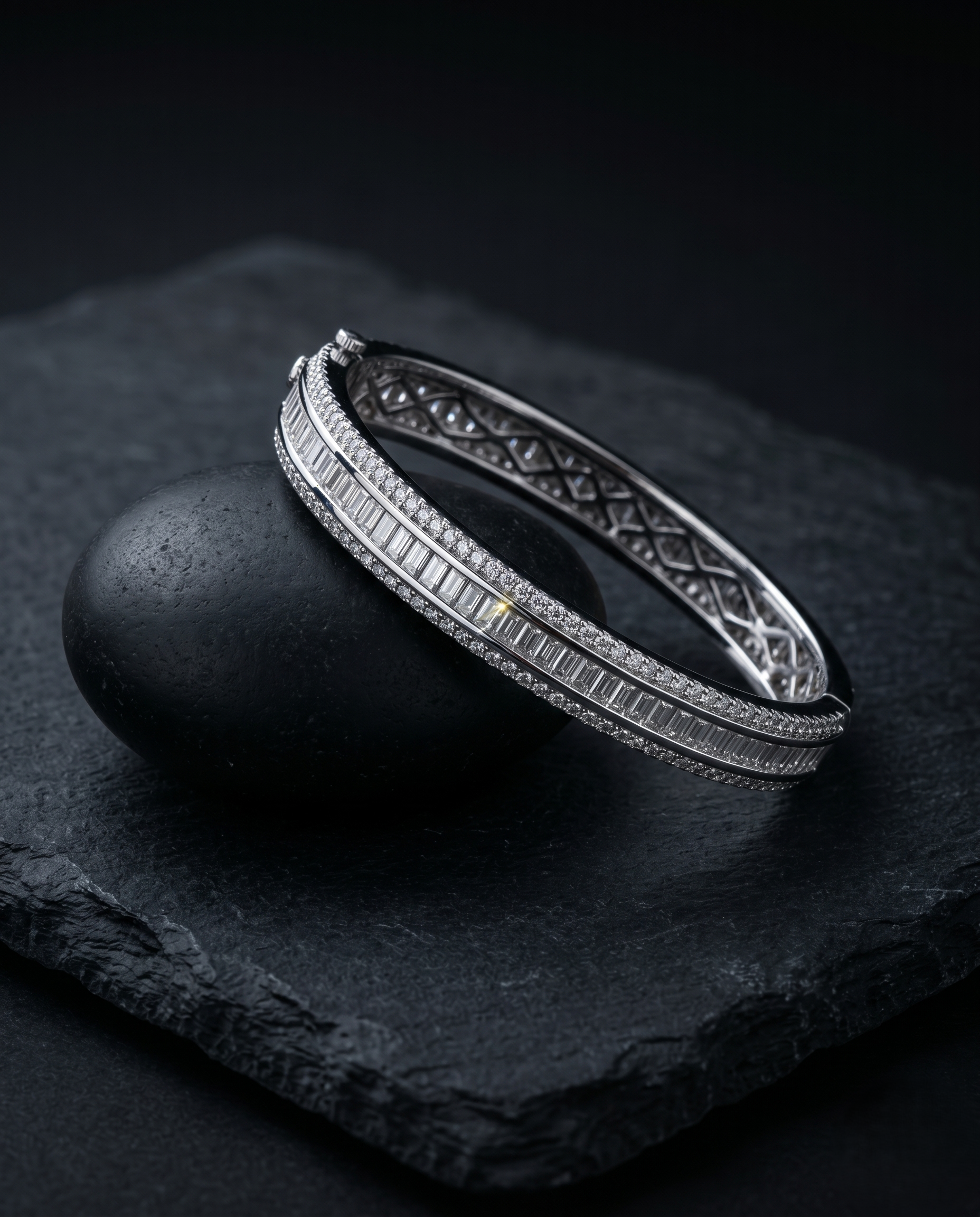 Silver bracelet with intricate design on a dark stone surface
