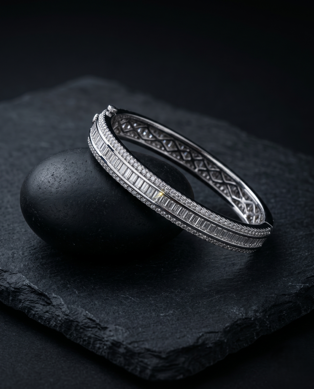 Silver bracelet with intricate design on a dark stone surface