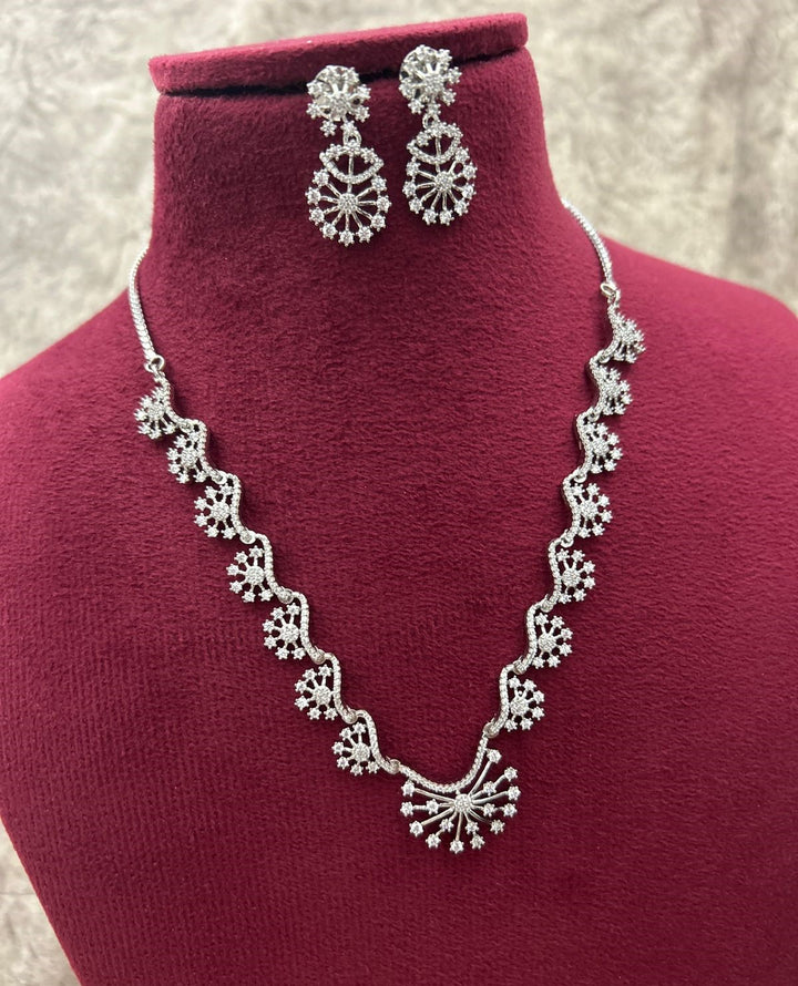 Silver necklace and earrings on a red mannequin bust